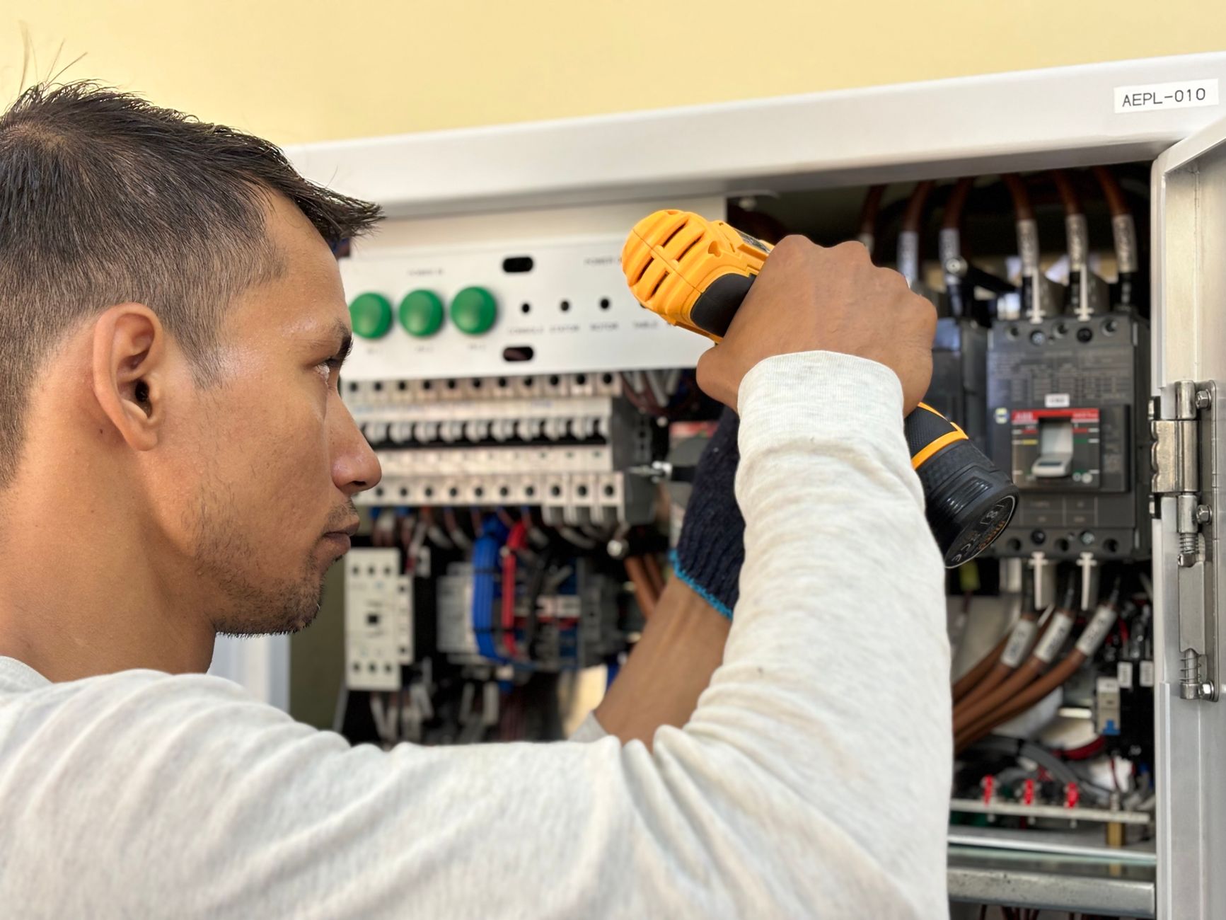 Elektriker prüft und verdrahtet einen offenen Sicherungskasten